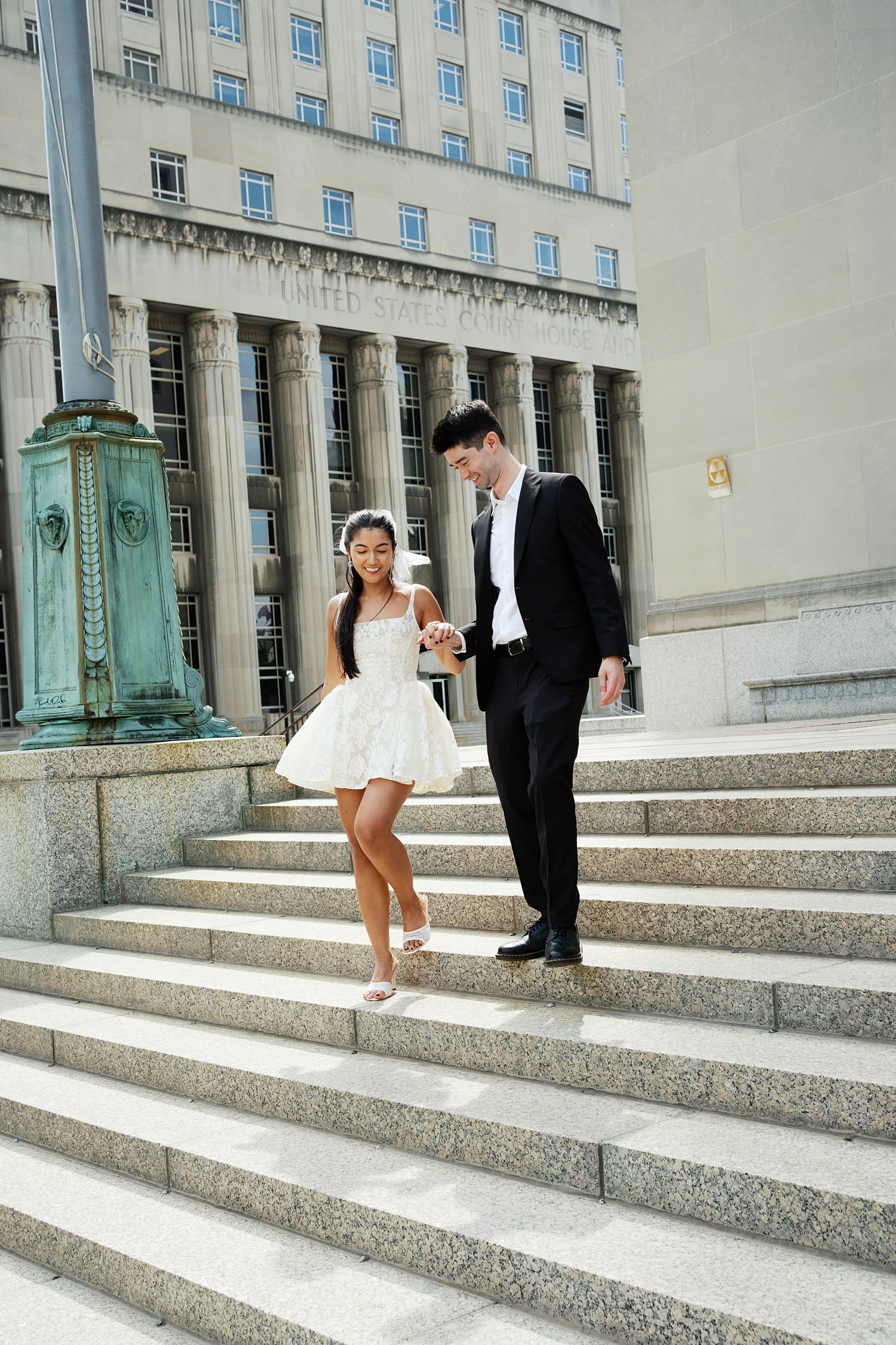 bride and groom exit down the steps at the St. Louis Courthouse