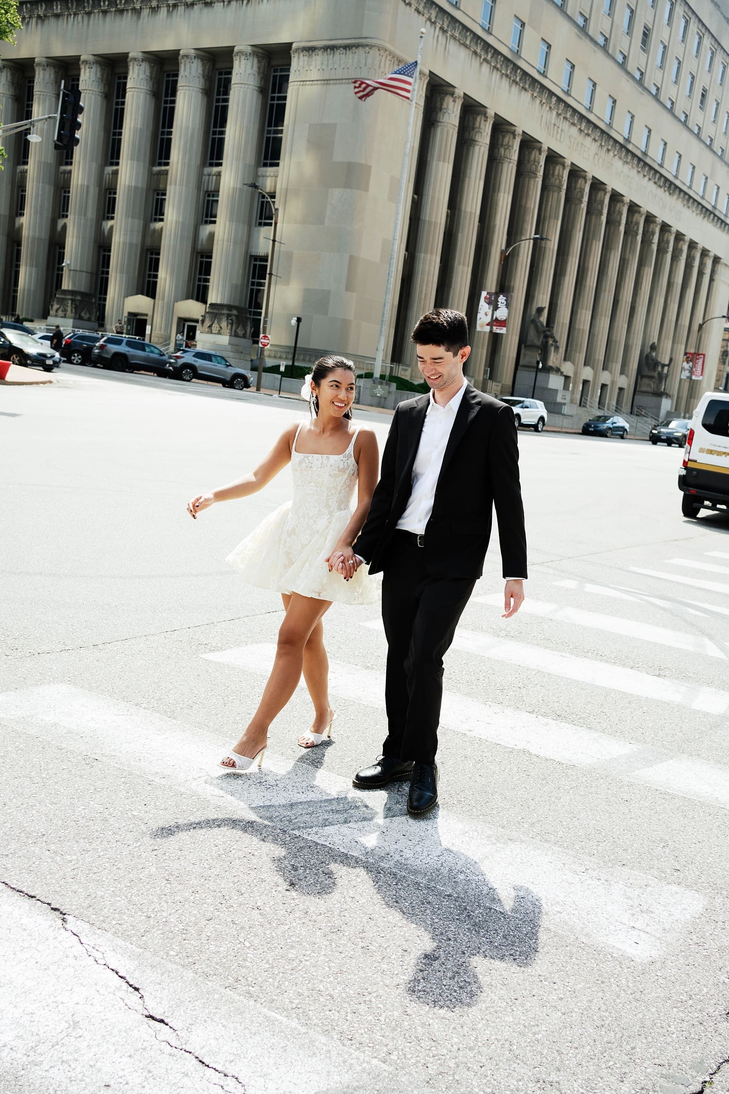 couple walk together across the crosswalk after eloping by Missouri elopement photographer