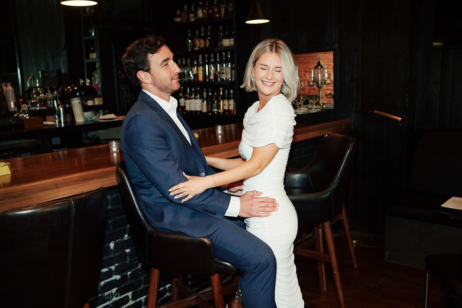 man in suit holds woman next to bar at Brennan's in Central West End