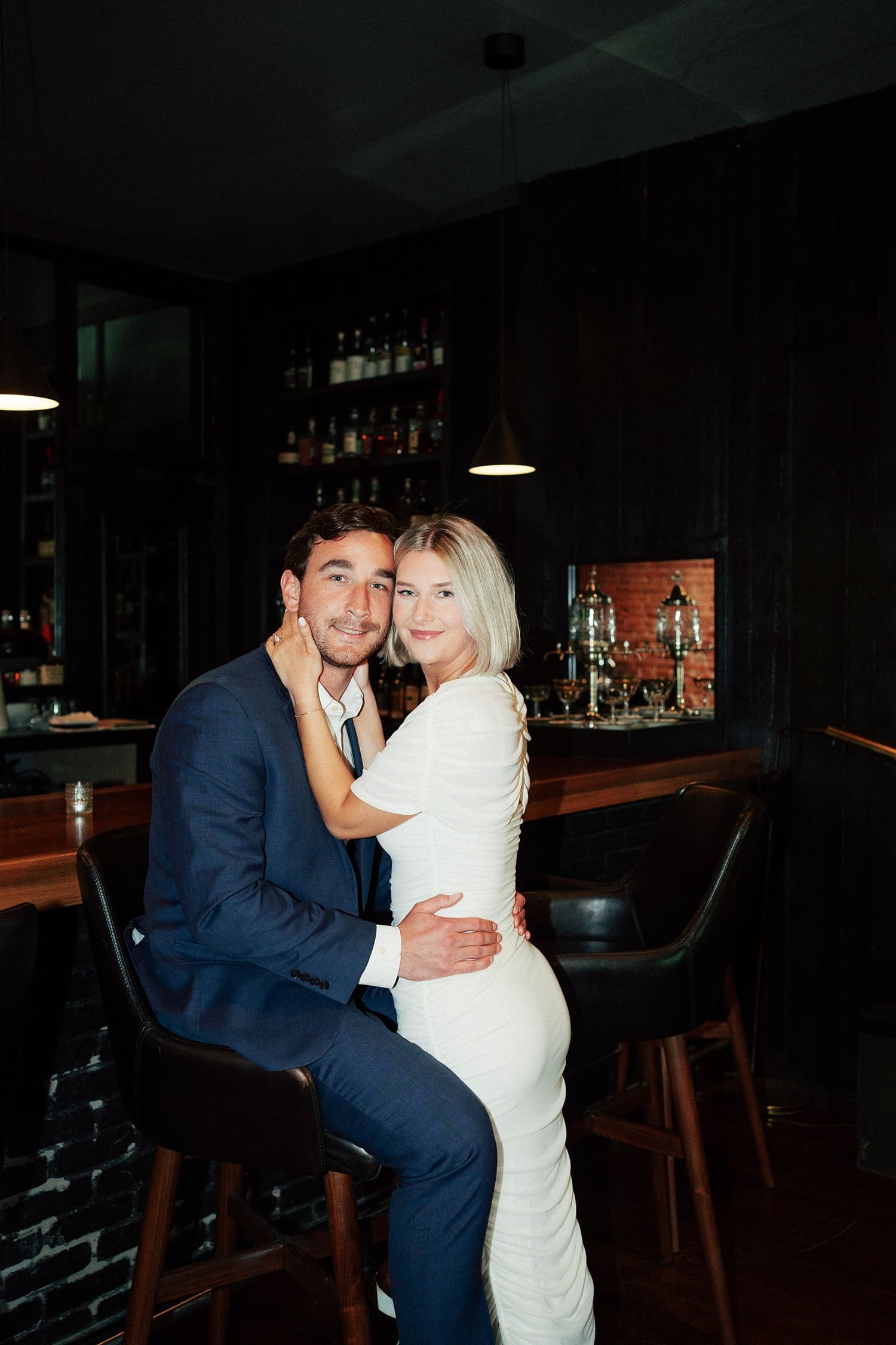 two people snuggle up at old historic bar by St. Louis wedding photographer