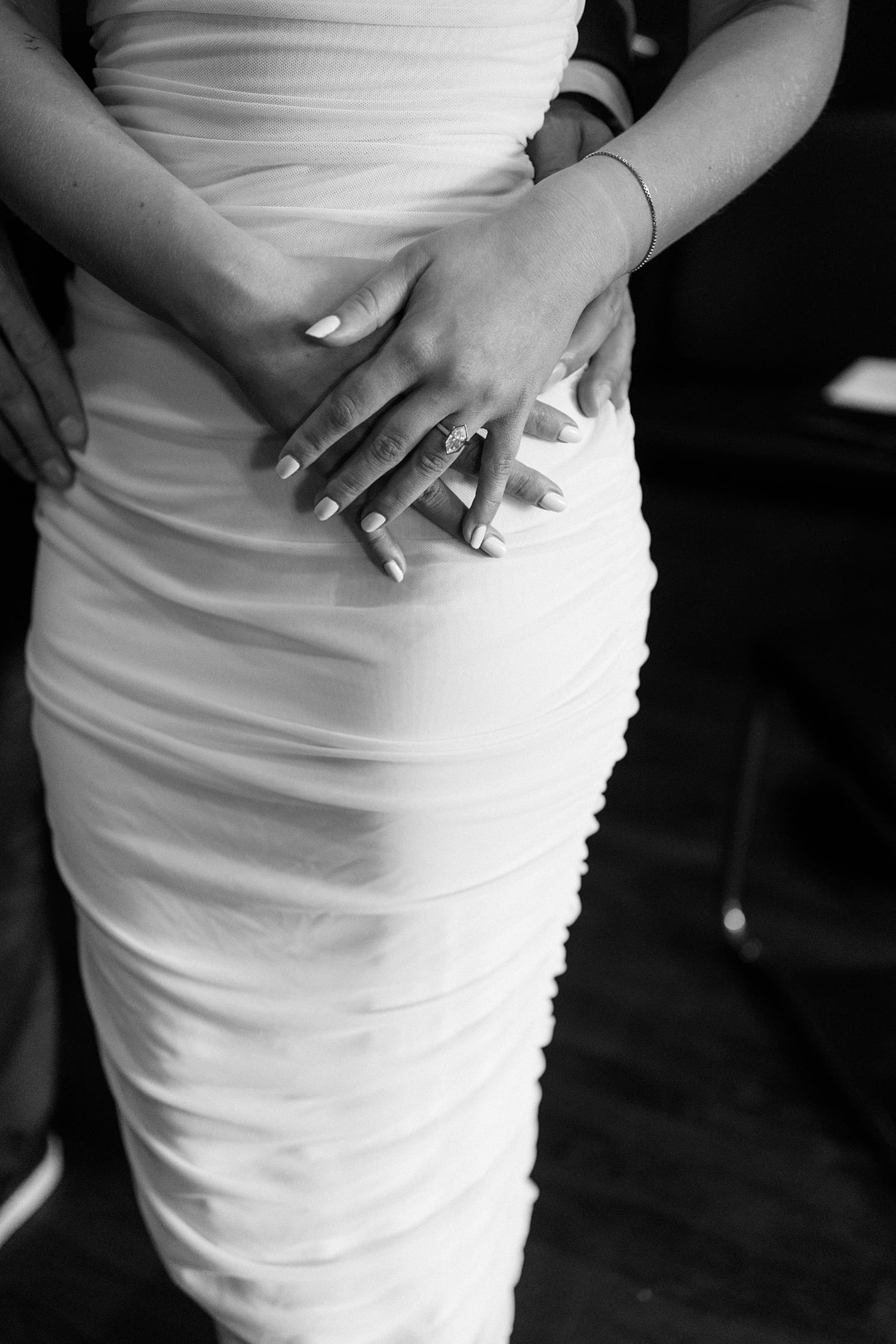 man holds his woman's hips while she shows off ring at Brennan's in Central West End