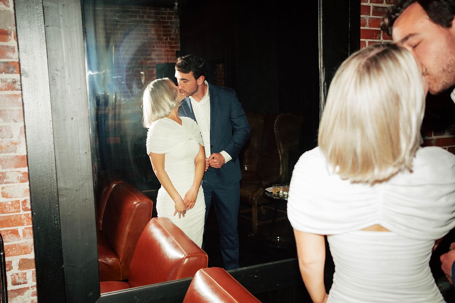 man and woman share a kiss near booth by St. Louis wedding photographer