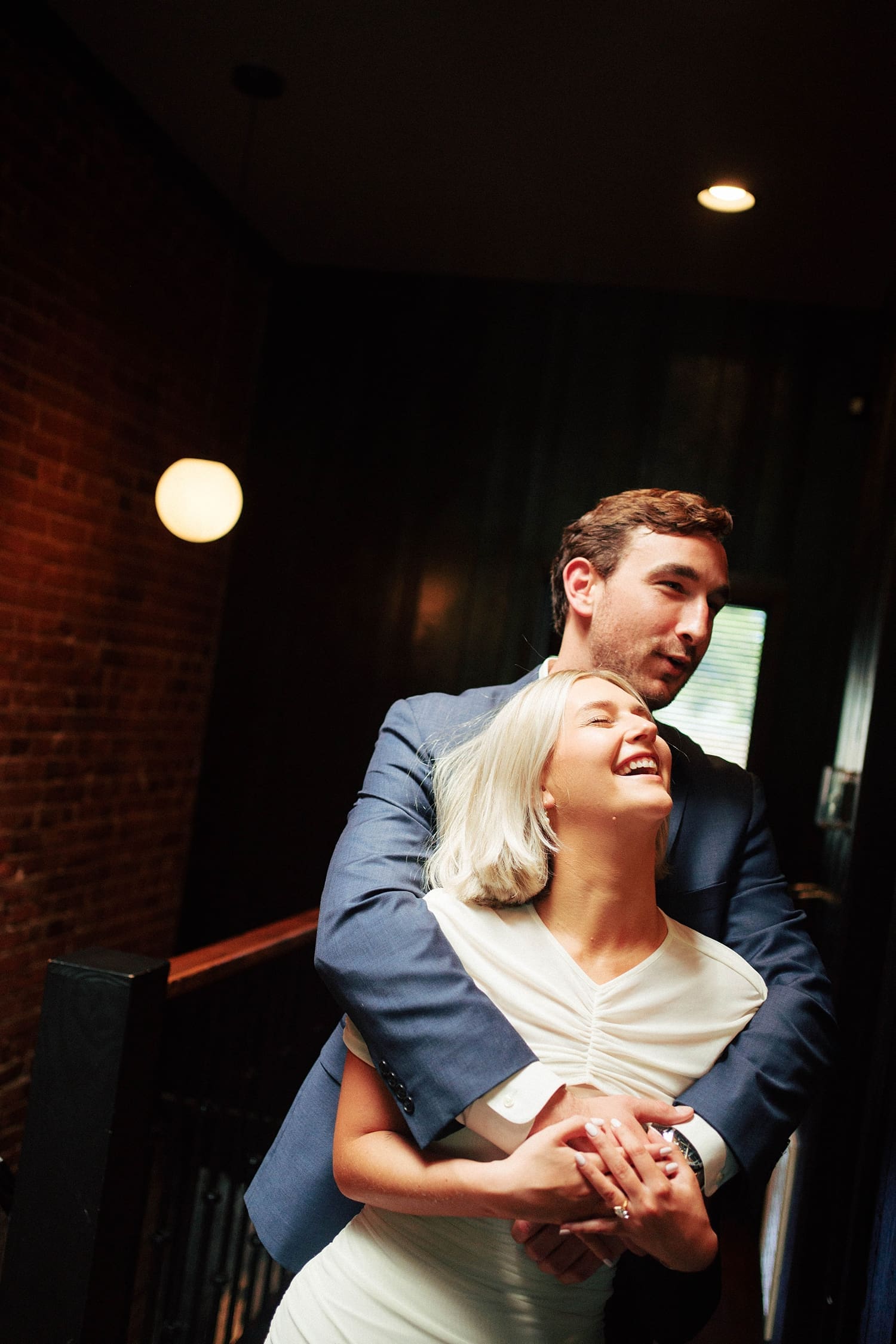 man wraps up his woman while she's laughing by St. Louis wedding photographer