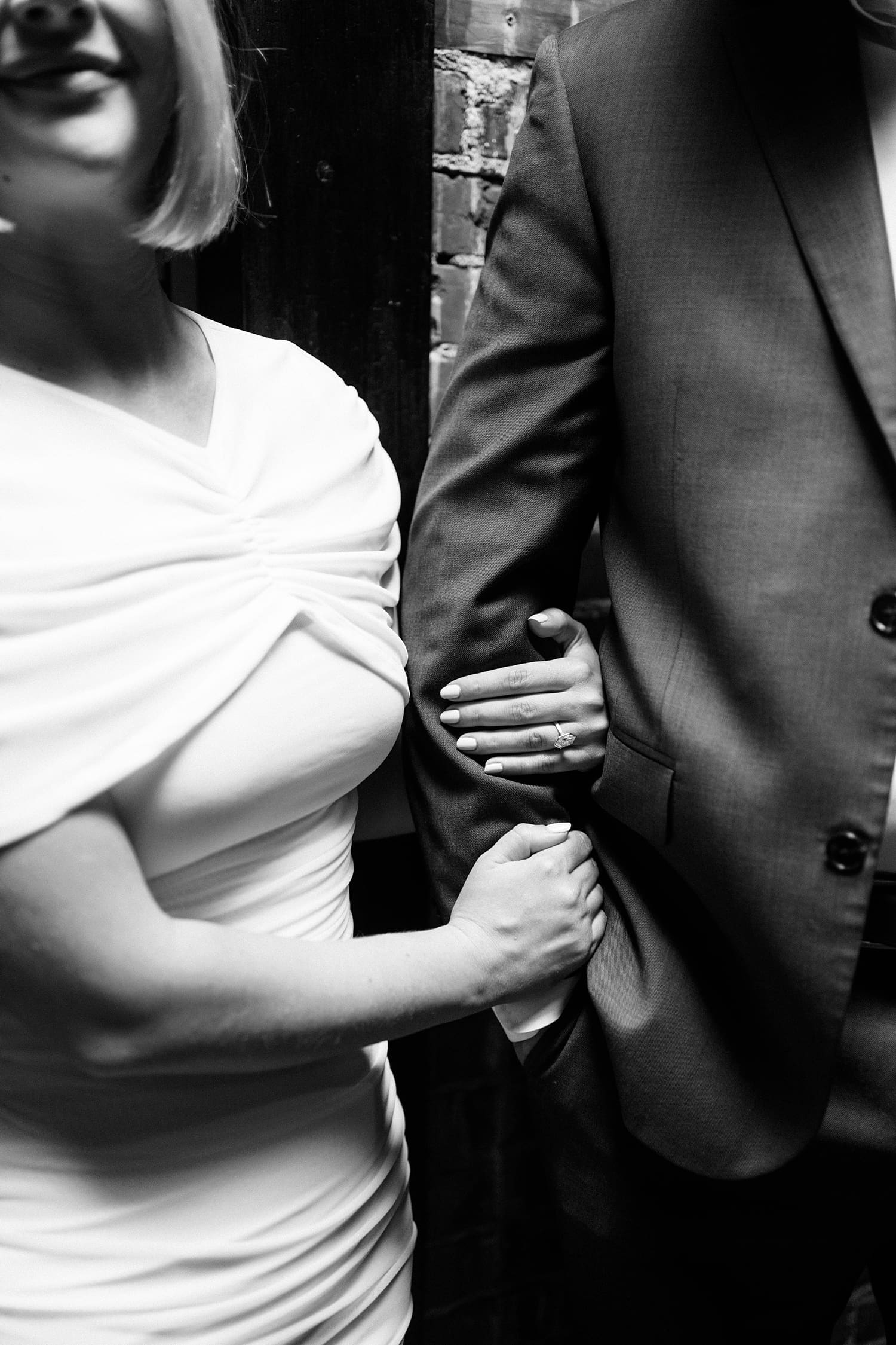 woman wraps her hand around man's arm by Camille Meers Photography