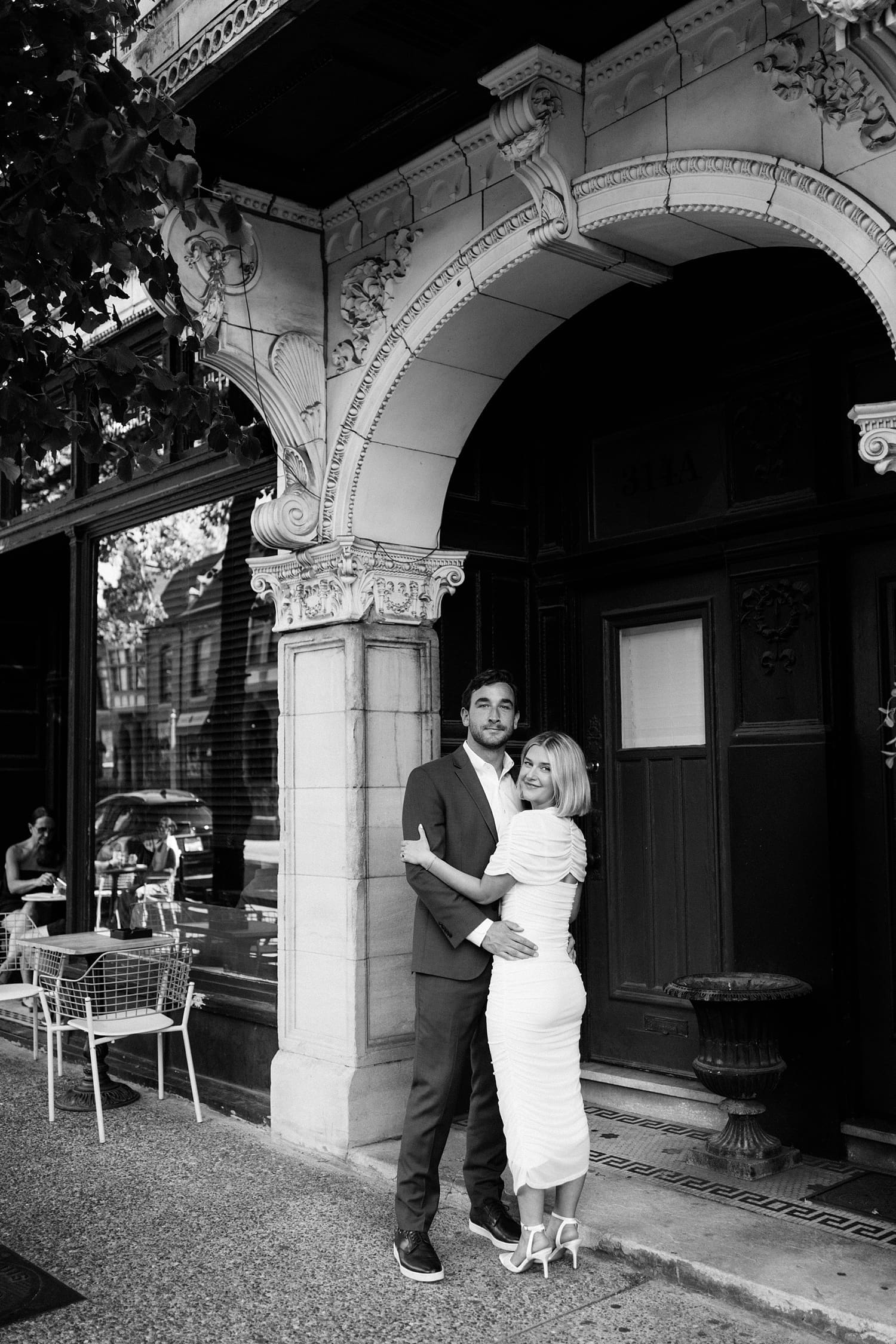 man holds his fiance in old archway by St. Louis wedding photographer
