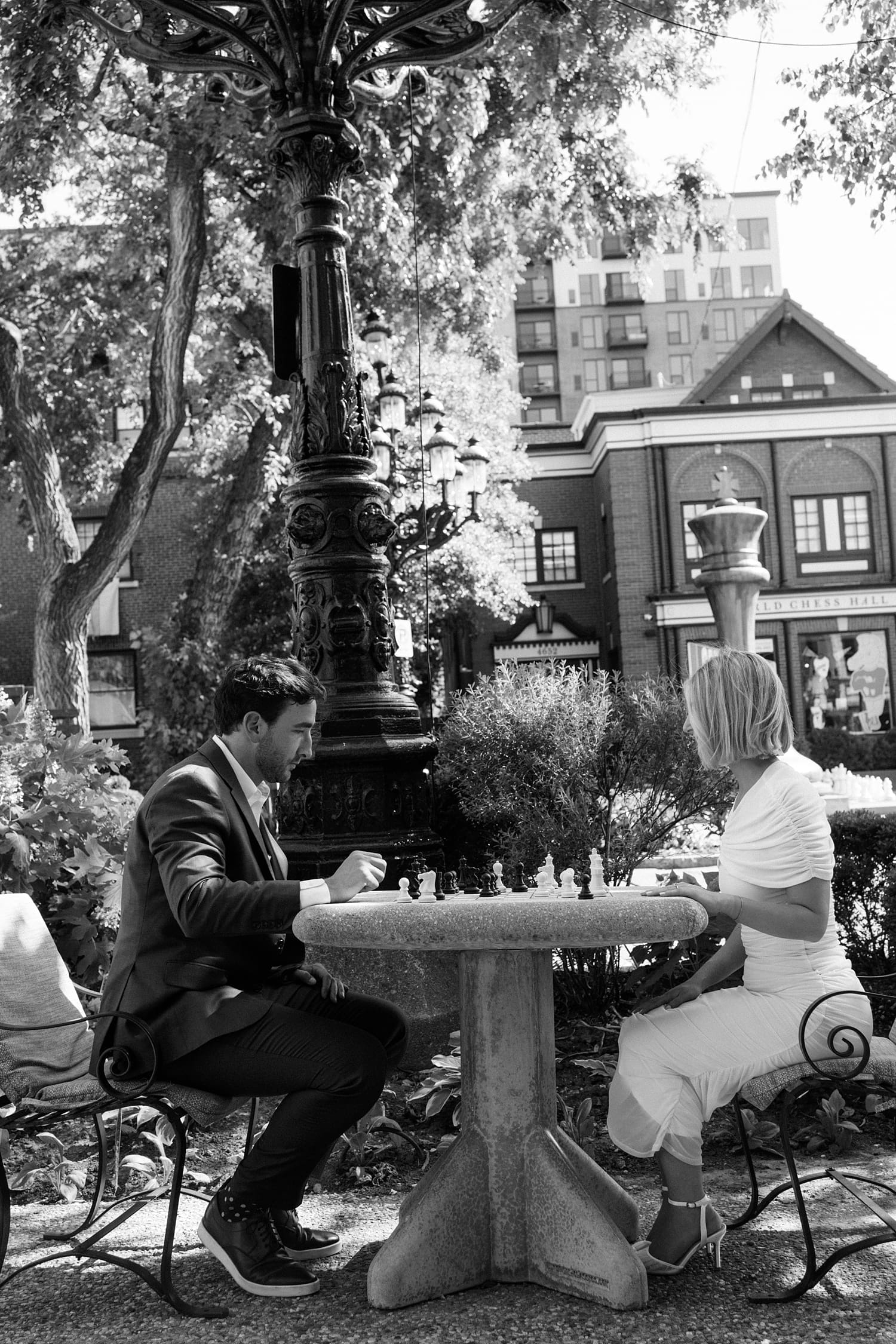 couple plays chess on street outside Brennan's in Central West End