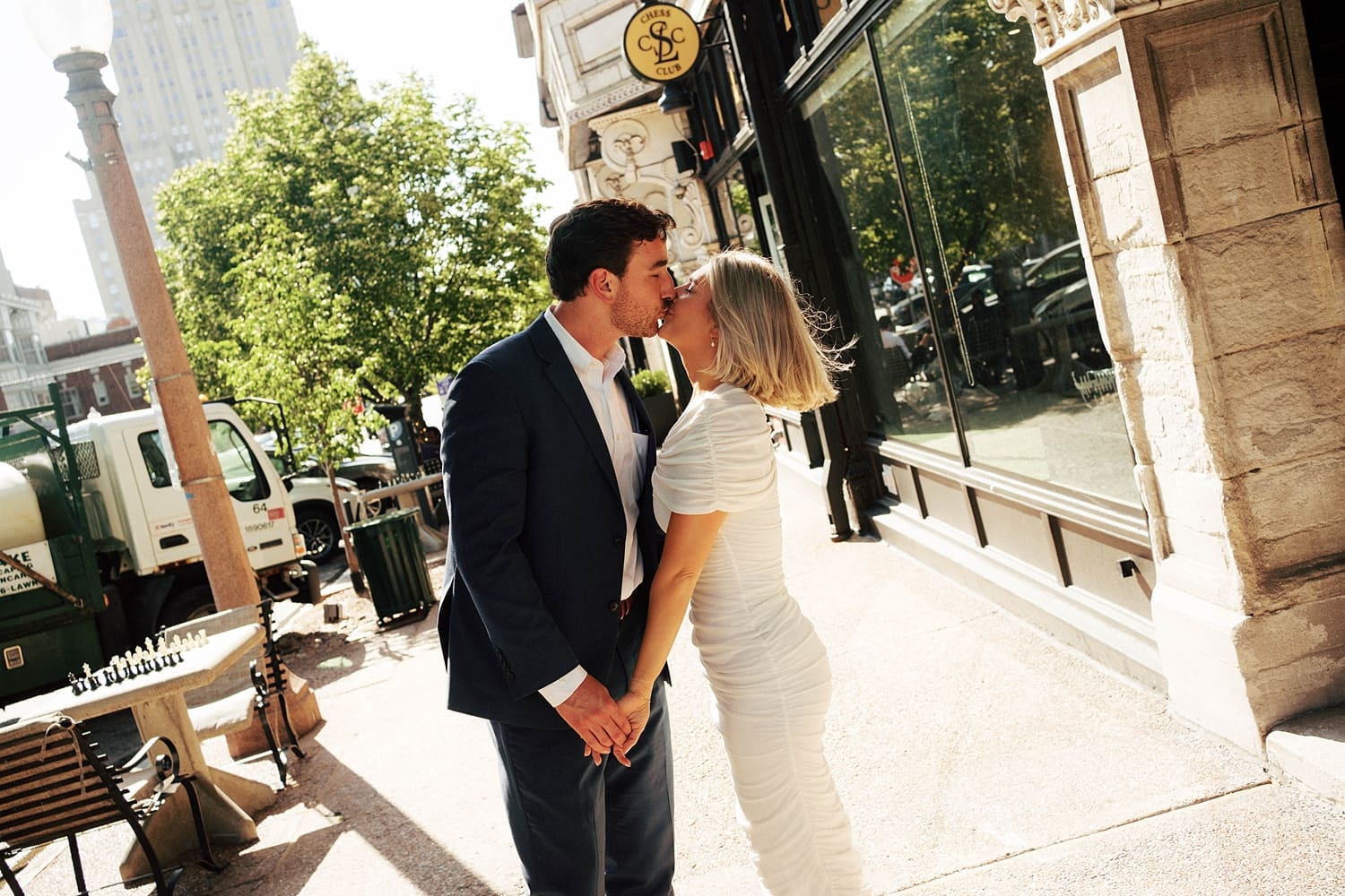 couple share a kiss on sidewalk by Camille Meers Photography