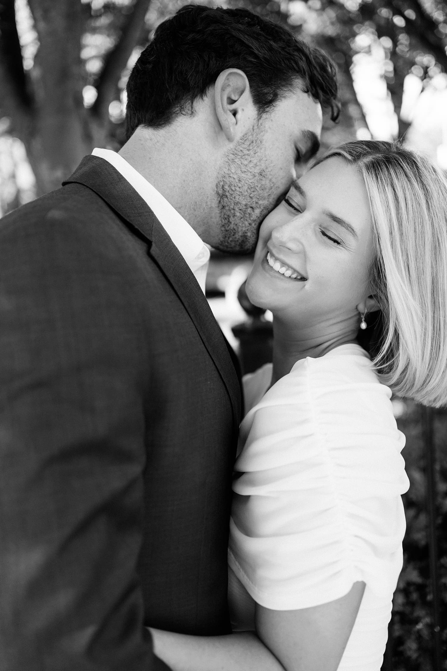 husband to be leans in to kiss his bride on the cheek by Camille Meers Photography